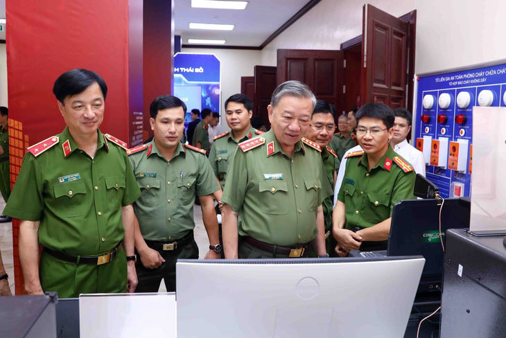 Bộ trưởng Tô Lâm cùng các lãnh đạo Bộ Công an, tham quan các thiết bị chuyển đổi số tại triển lãm - Ảnh: DANH TRỌNG